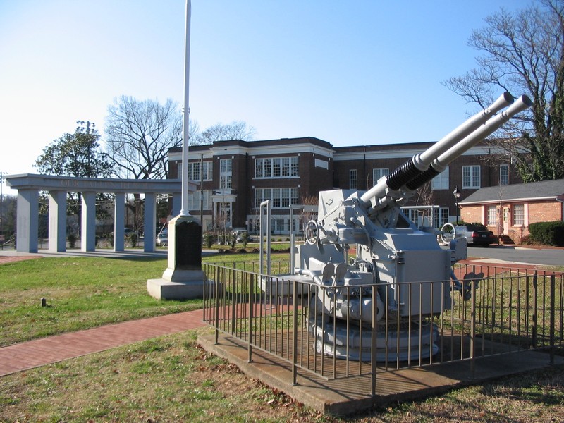 The WWII 40mm antiaircraft gun, WWI memorial flagpole, and Fredericksburg Area War Memorial — focal points for remembrance.